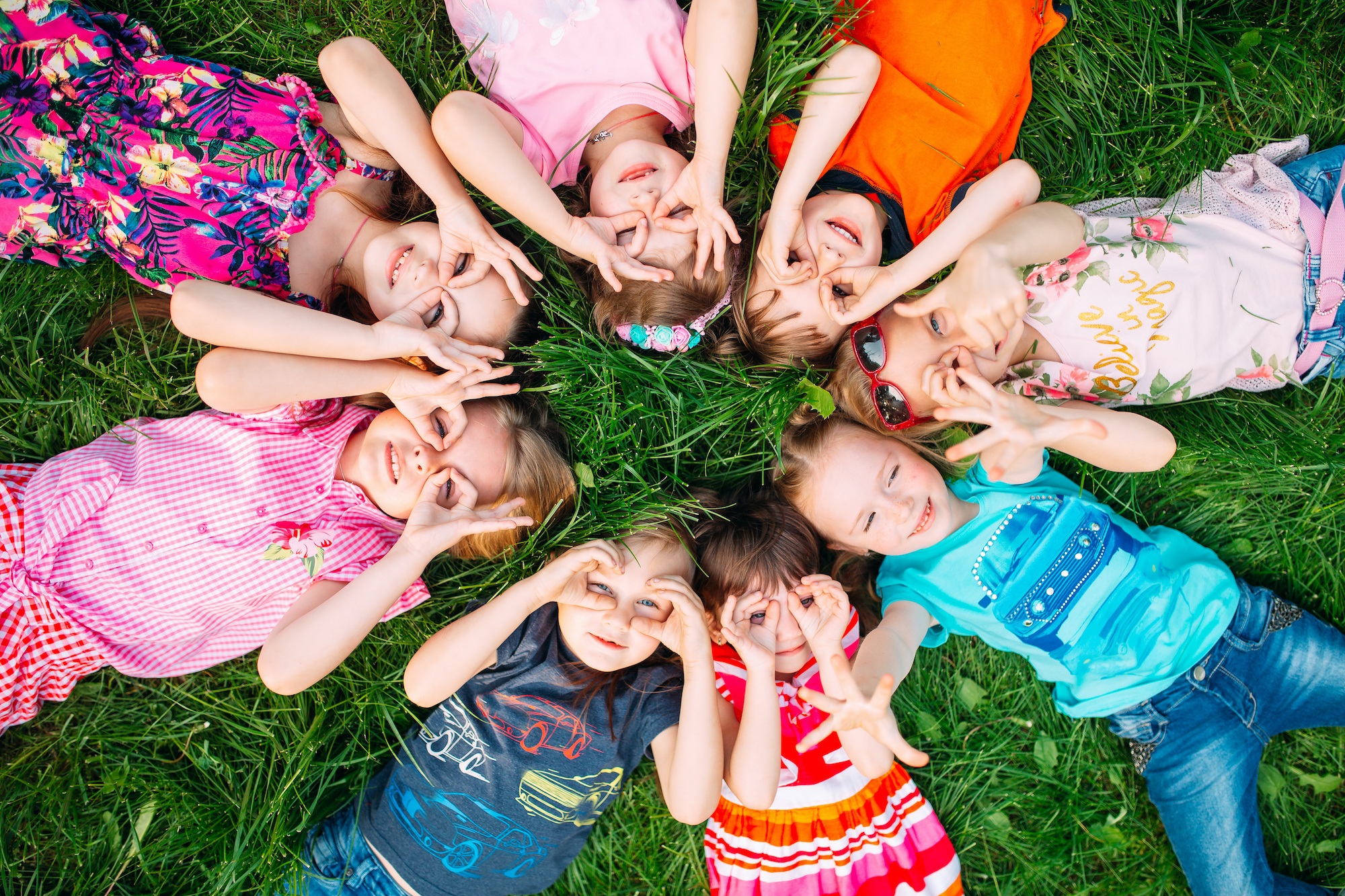 Family Care in New Jersey a group of children lying on the green grass in the Park. The interaction of the children. Family Care in New Jersey group of children
